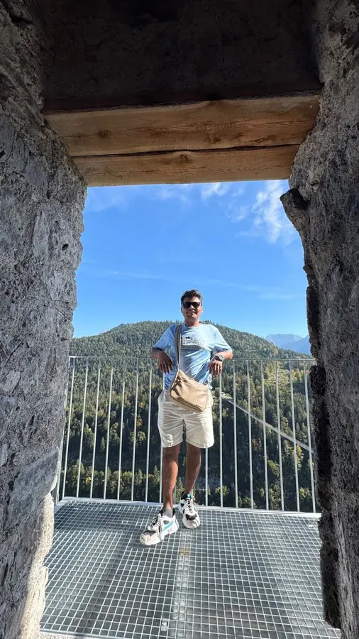 Saad on a lookout platform above an alpine valley